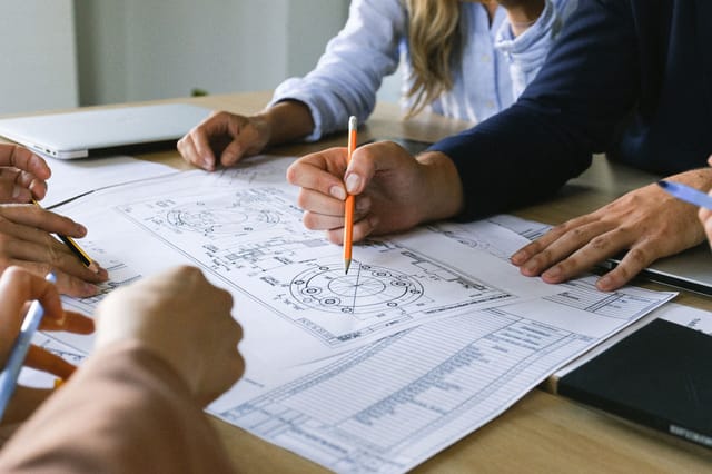 Engineers marking up an equipment drawing with a pencil during inspection planning
