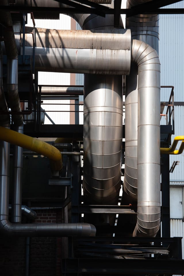 Insulated process vessels and lagged pipework close up at an industrial plant
