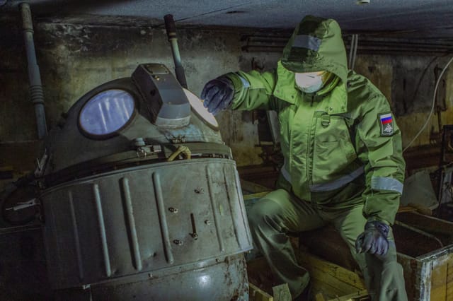 Inspector in protective equipment beside a vessel inside a confined space