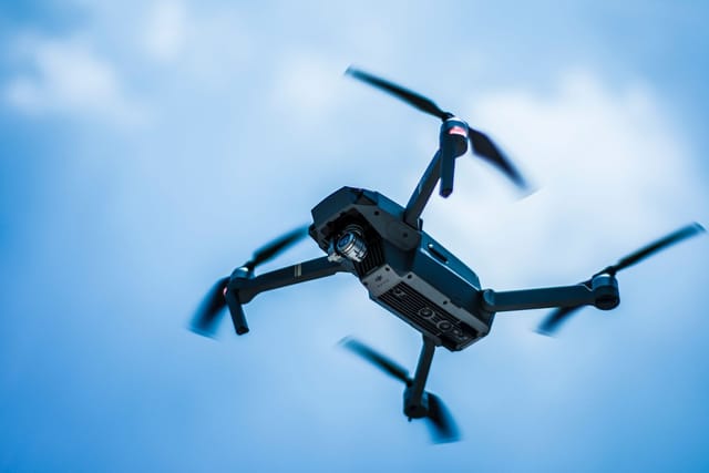 Inspection drone with a camera against a clear blue sky